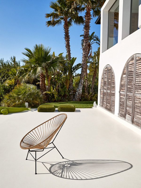 Original Acapulco Chair in der Farbe beige auf Terrasse vor Palmen