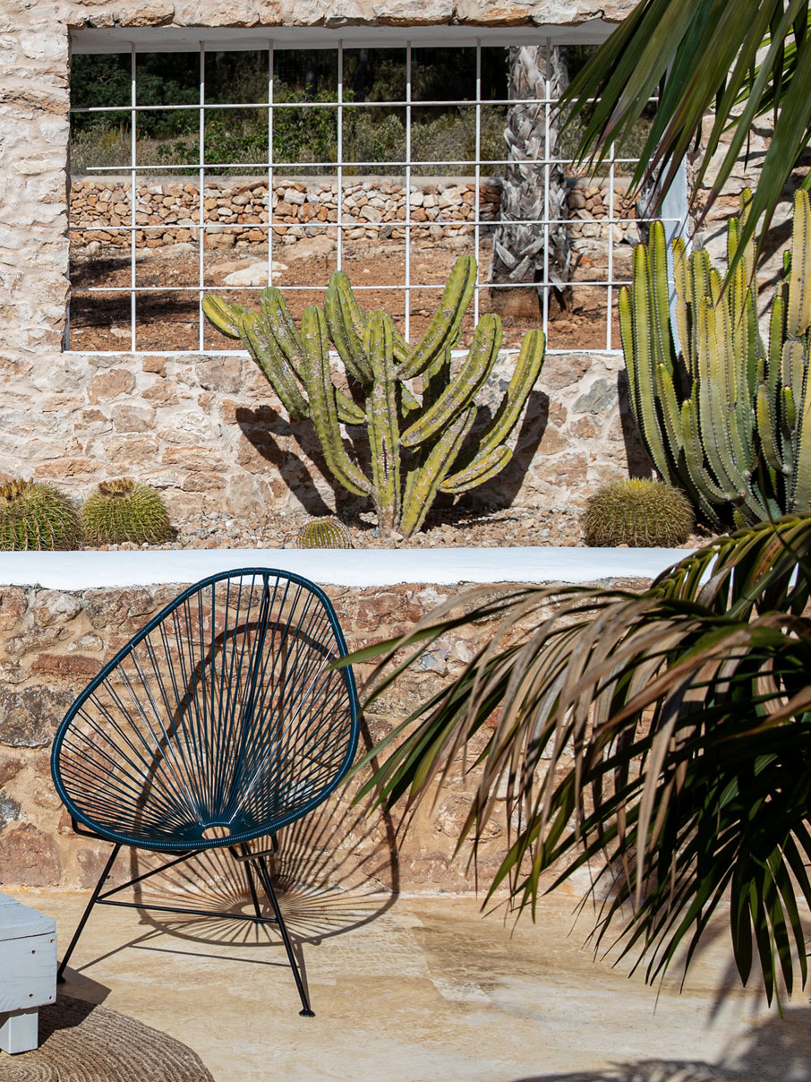 Original-Acapulco-Chair-petrol Original Acapulco Chair in der Farbe petrol vor gemauerter Wand mit Kakteen