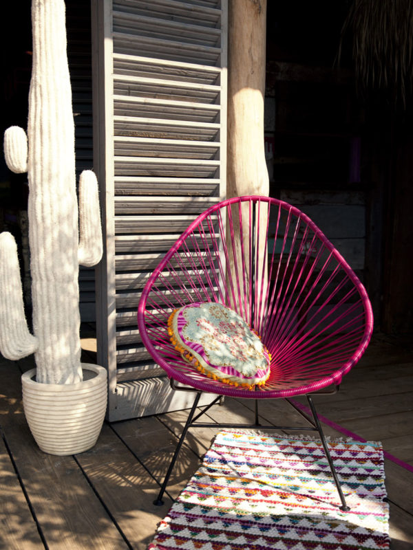 Original Acapulco Chair in der Farbe pink vor Holztür